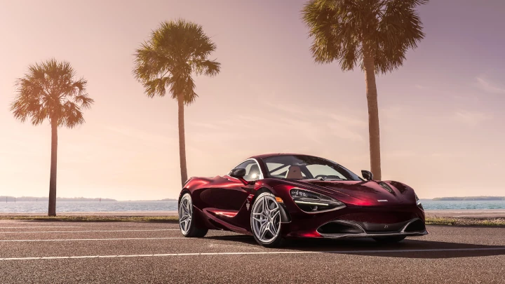 A scaled down version of the image used to test your internet speed shows a red McLaren 720S parked near palm trees by the water